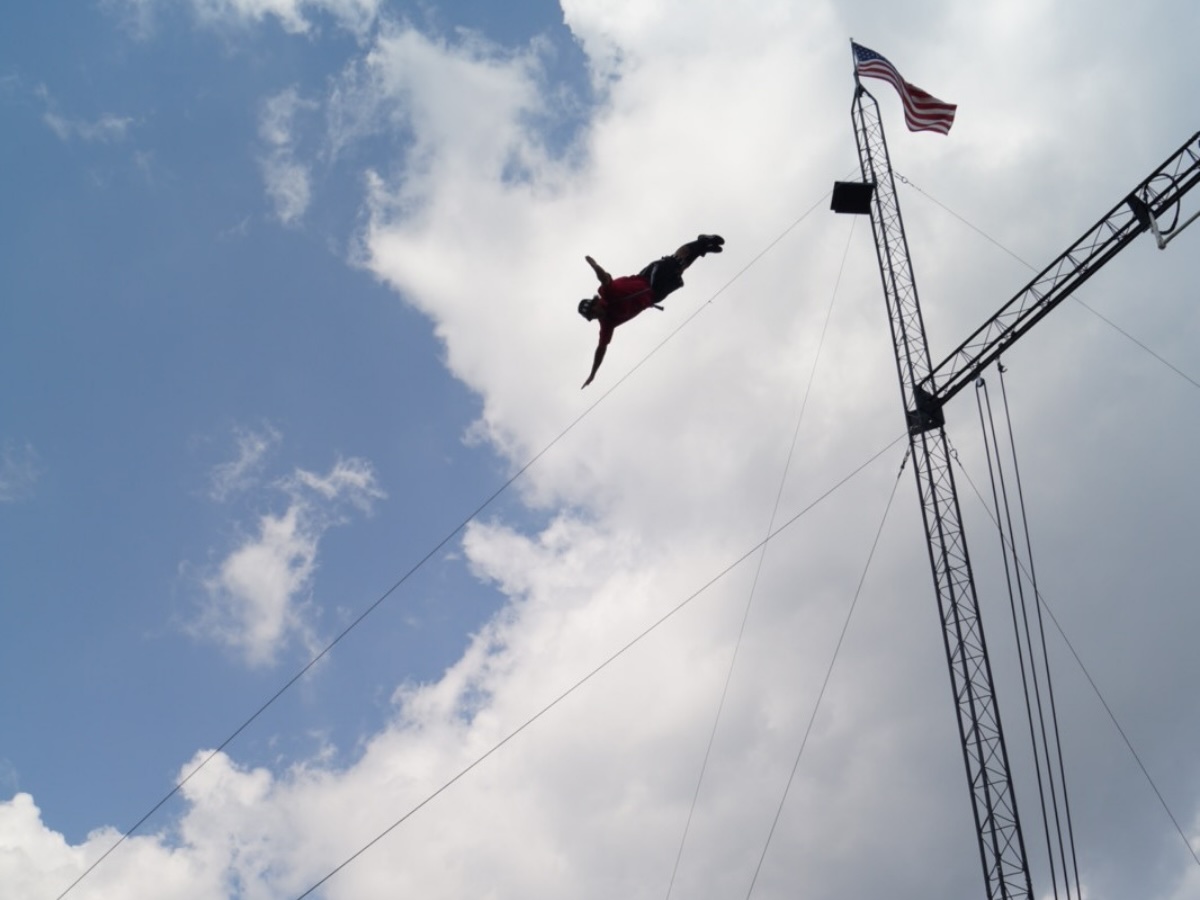 Artiste de cirque effectuant un high fall, saut en chute libre depuis une très haute plateforme