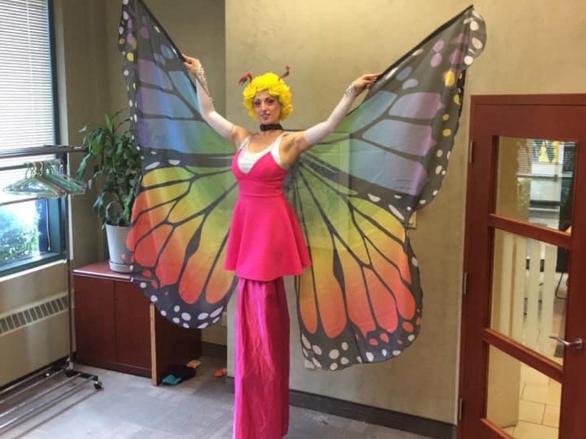 Échassière incarnant un papillon géant, animation poétique et haute en couleur.