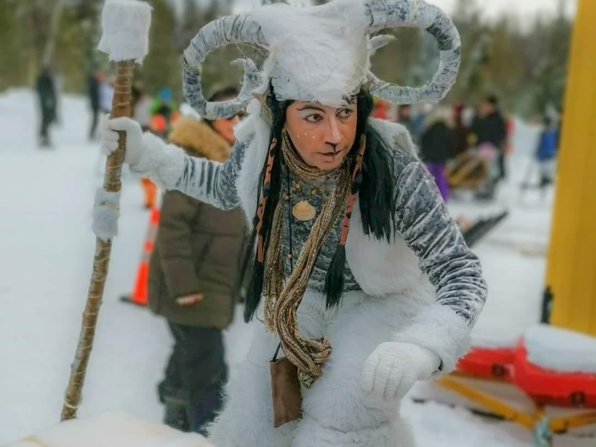 Personnage d’hiver inspiré d’un satyre ou faune des neiges, habillé d’un costume blanc évoquant un esprit de la forêt mystique en pleine animation