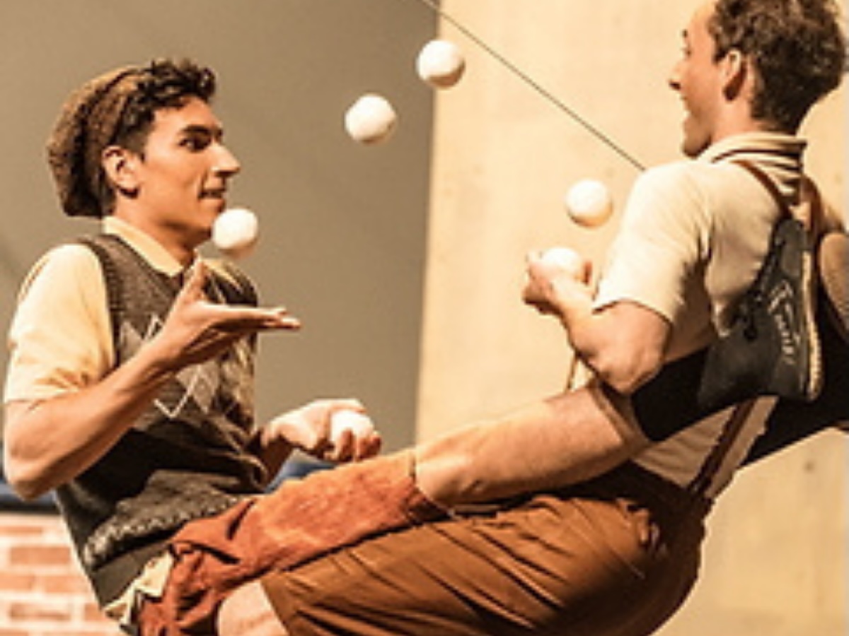 Duo d'artistes de cirque en position de chaise acrobatique, en pleine démonstration de jonglerie.