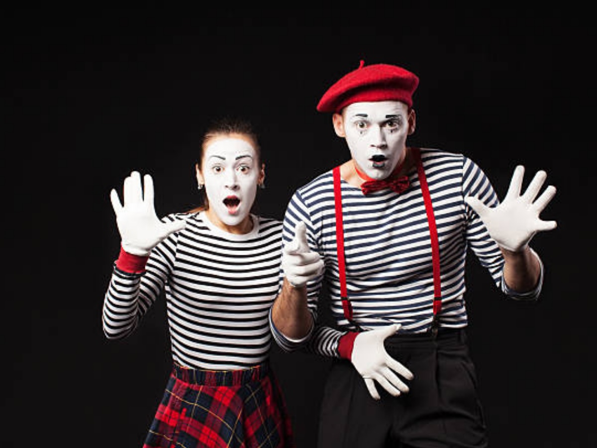 Duo de mimes élégants, style classique avec maquillage blanc, chandails rayés et gants immaculés