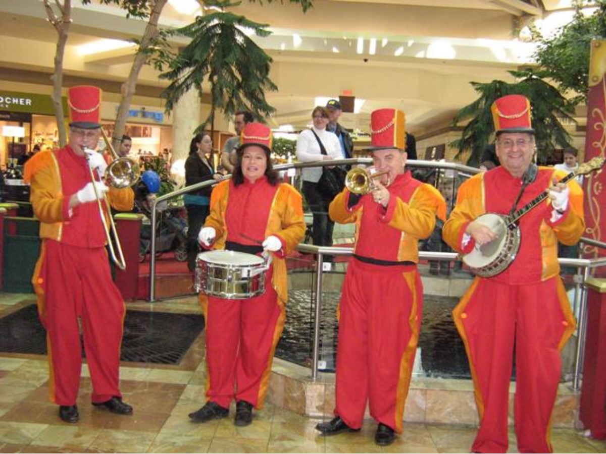 Ensemble musical en uniforme rouge et orange style soldat, jouant dans un événement public