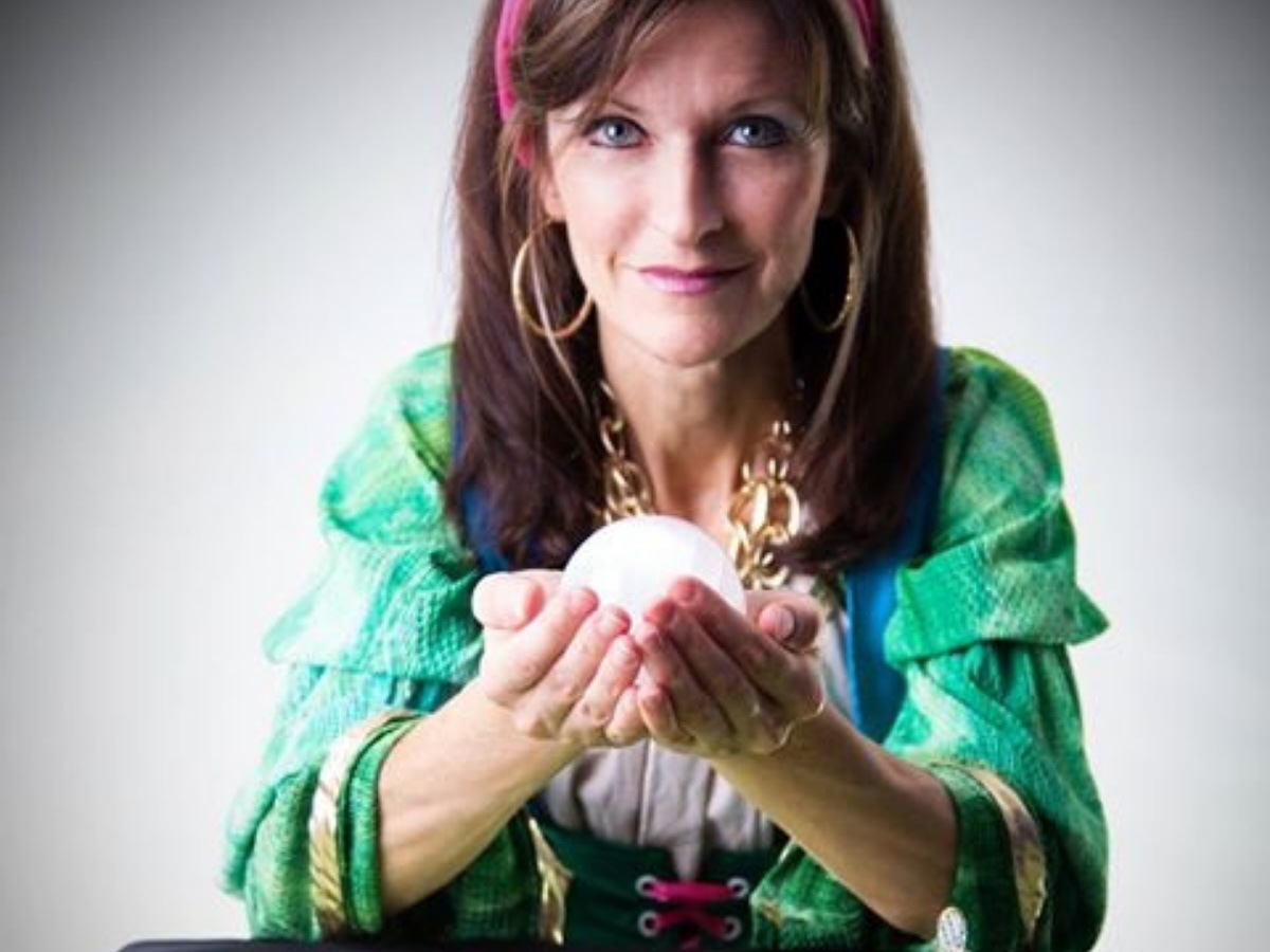 Personnage thématique de diseuse de bonne aventure, habillée de façon mystique et entourée d’accessoires ésotériques