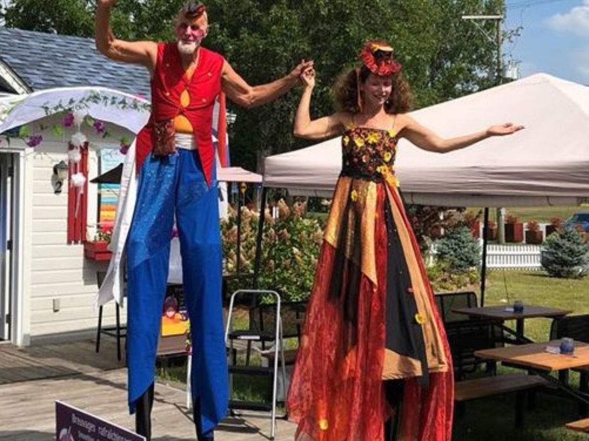 Deux échassiers costumés dans un style d’époque coloré, en animation déambulatoire.